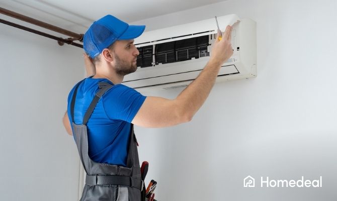 Airco installateur plaatst een airco tegen de muur