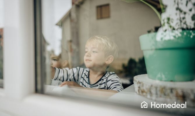 kind kijkt vanaf binnen door raam