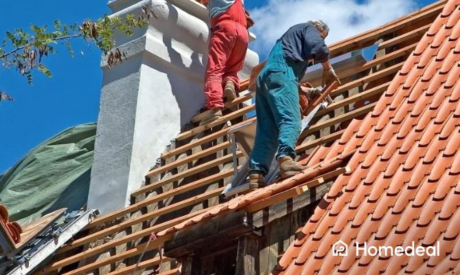 2 vakspecialisten bezig met het leggen van een nieuw dak