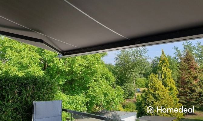 Terras uitkijkend over de tuin met een zonnescherm erboven