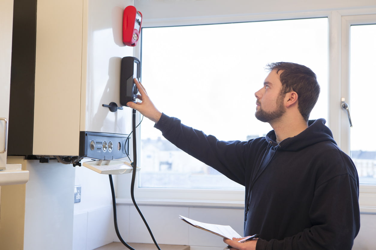 man controleert cv ketel met meter