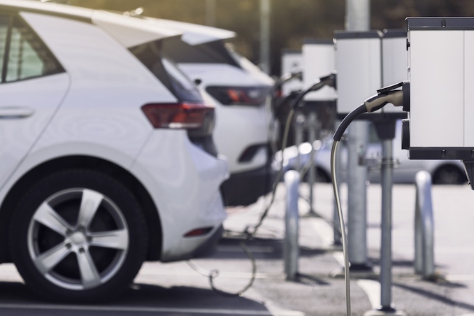 Een parkeerplaats met een paar auto's die opladen aan publieke laadpalen