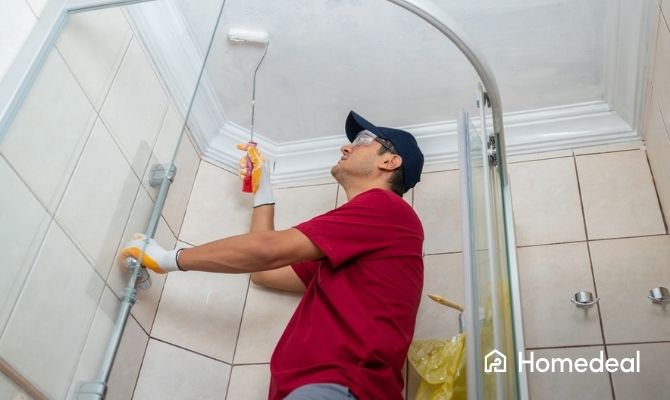 Schilder is een plafond in de badkamer aan het verven